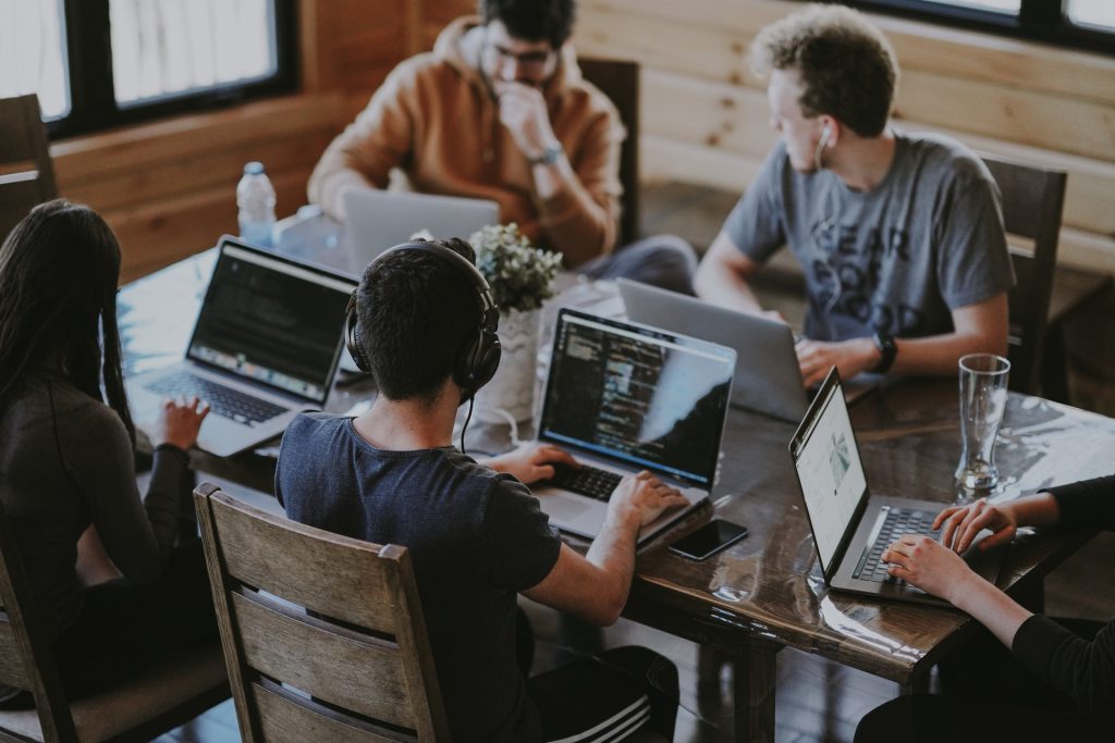 Team meeting at a table working on computers